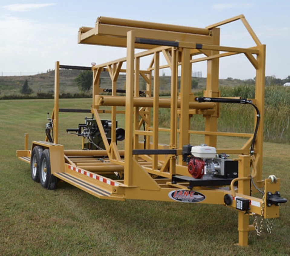 Yellow utility pipe handling trailer with protective rack and industrial equipment frame
