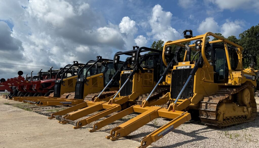 Multiple Caterpillar dozers lined up outdoors for utility and heavy construction projects