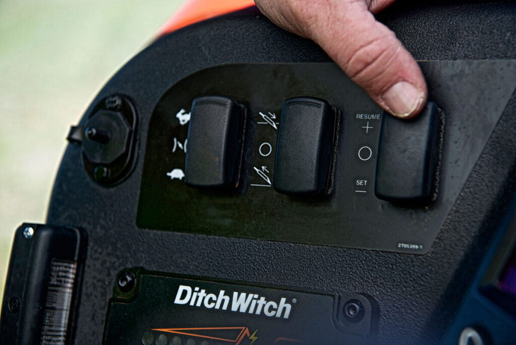 Operator using the control switches on a Ditch Witch JT20 directional drilling machine
