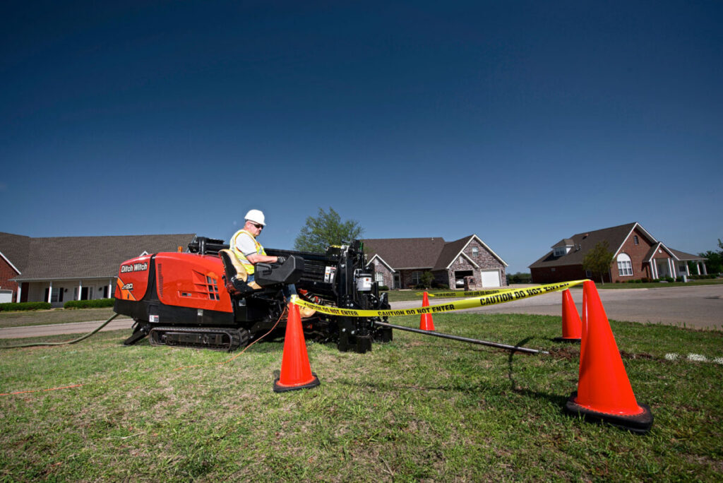 Ditch Witch JT20 directional drill with operator working in a residential neighborhood