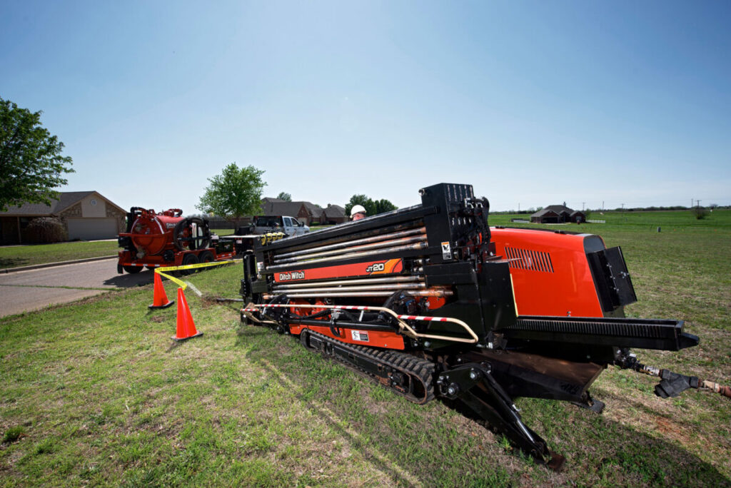 Ditch Witch JT20 directional drill positioned for underground utility work near homes